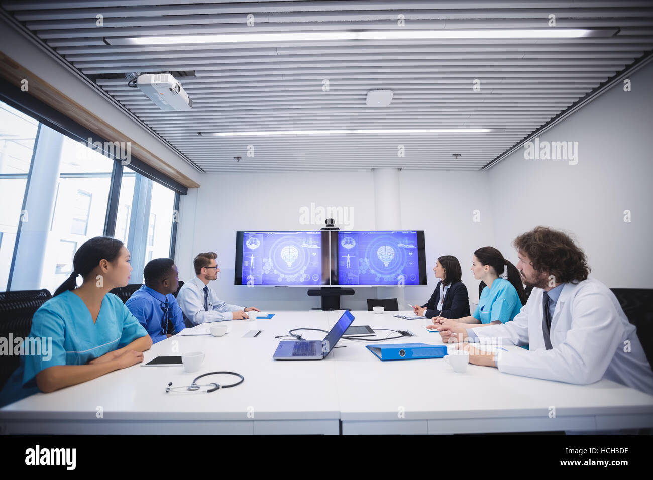 Team of doctors looking at screen in conference room Stock Photo