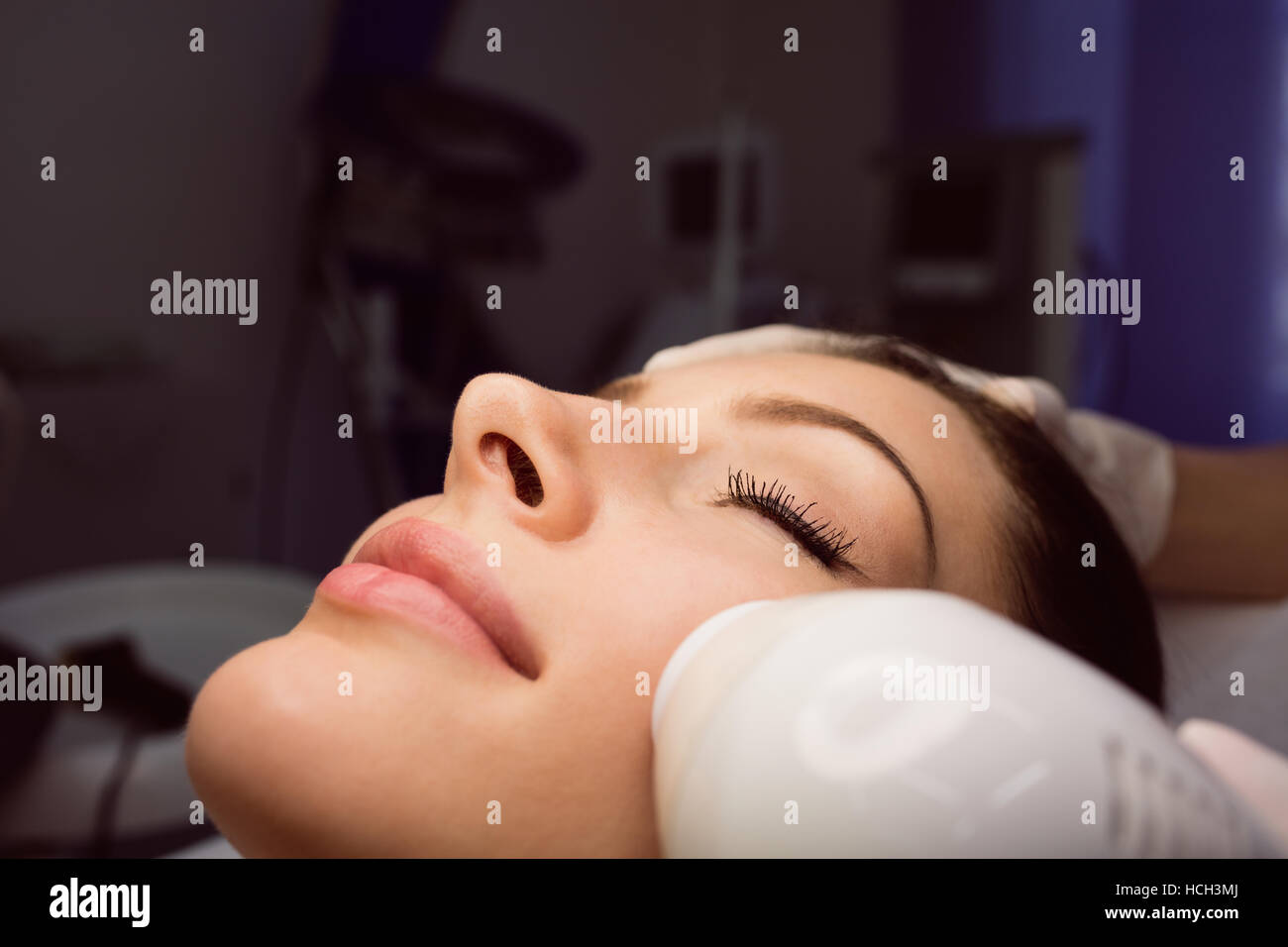 Dermatologist giving facial massage through sonic lifting Stock Photo