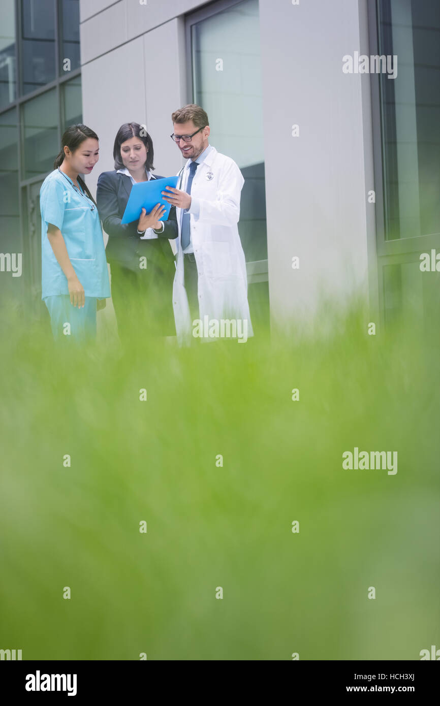 Doctors and nurse discussing over report Stock Photo