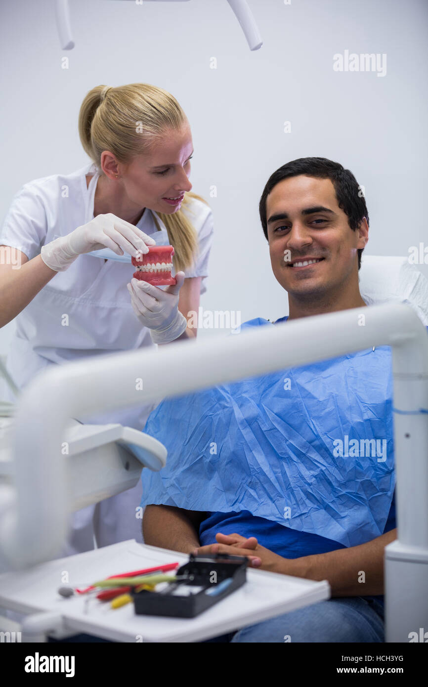Dentist showing set of model teeth to the patient Stock Photo