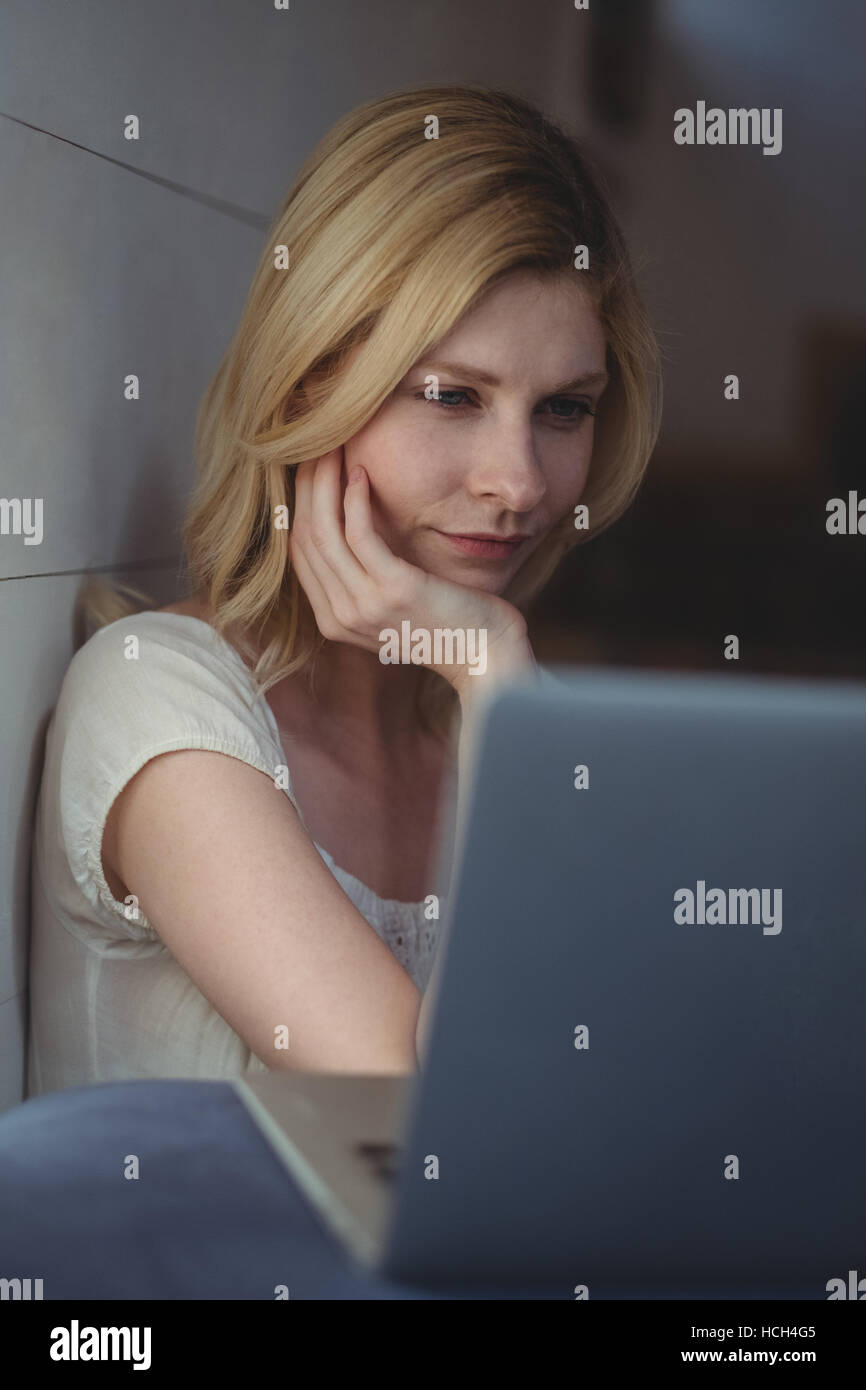 Beautiful woman using laptop in living room Stock Photo - Alamy