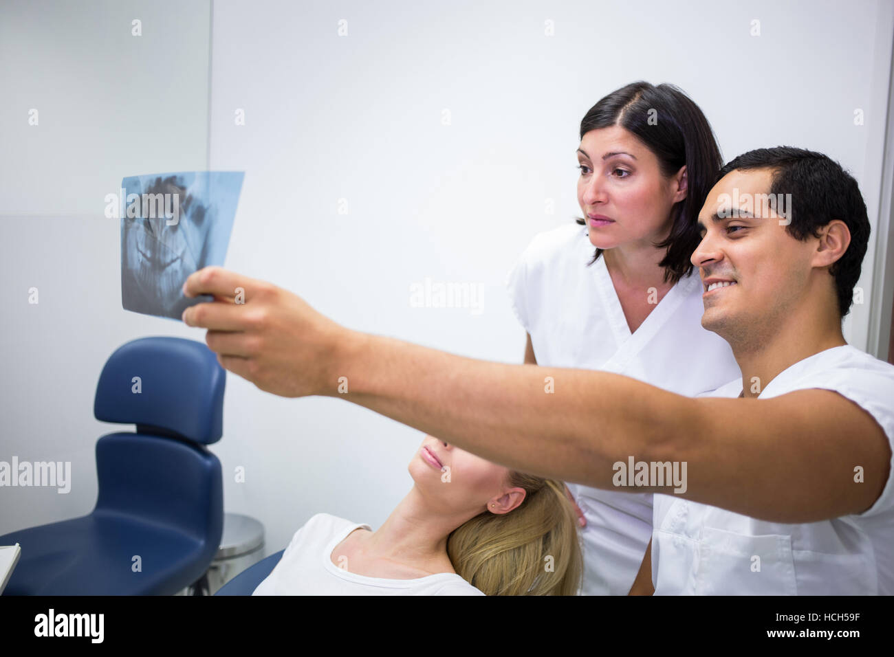 Dentists discussing x-ray in front of patient Stock Photo
