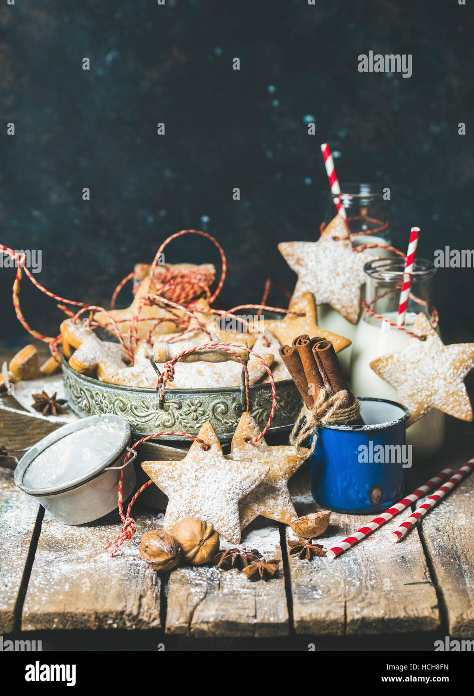 Christmas festive gingerbread cookies or biscuits in vintage tray, decoration rope, nuts, spices, milk for Santa in bottles, sugar powder. Selective f Stock Photo