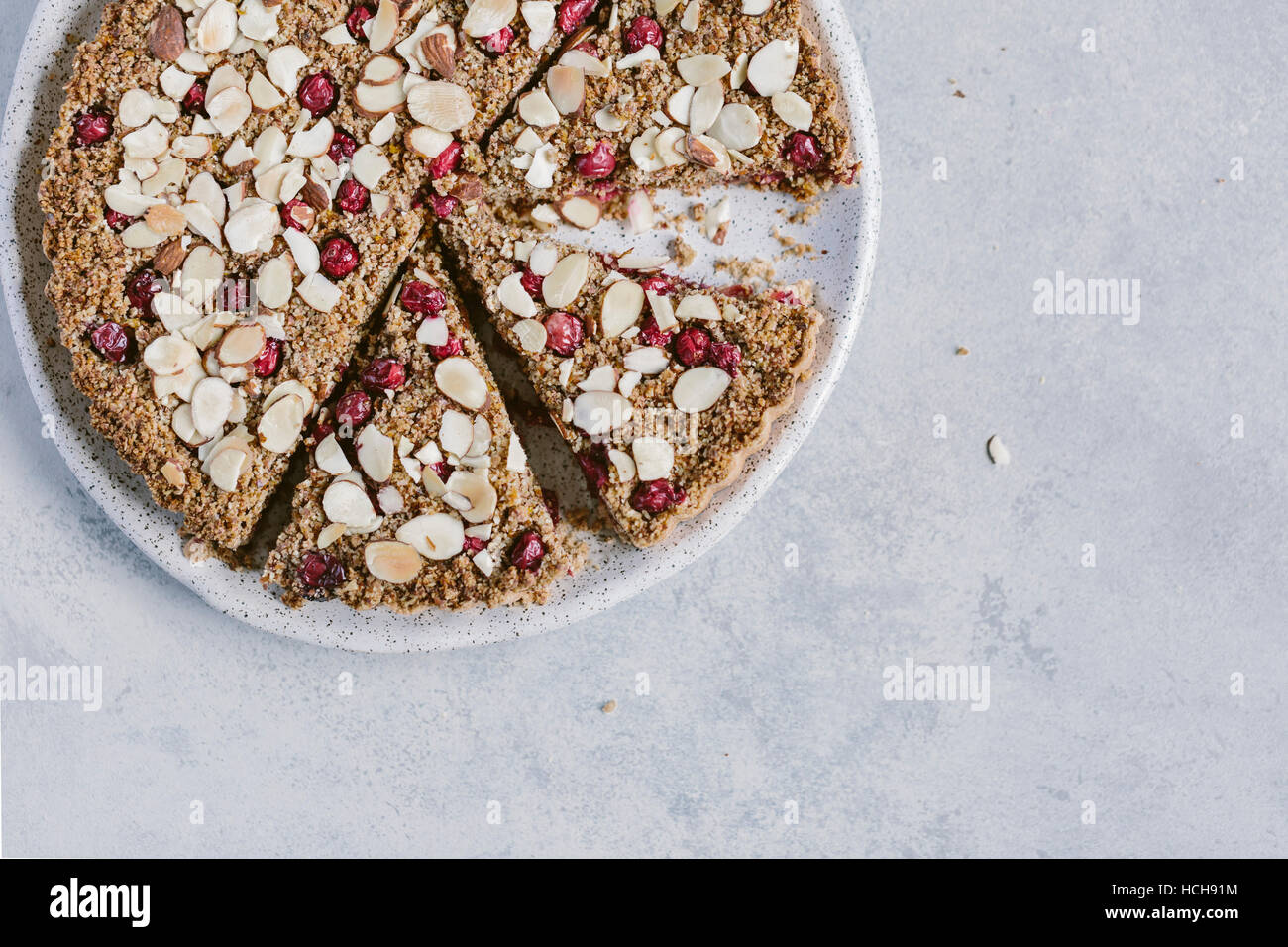 A sliced cranberry almond tart is photographed from the top view. Stock Photo
