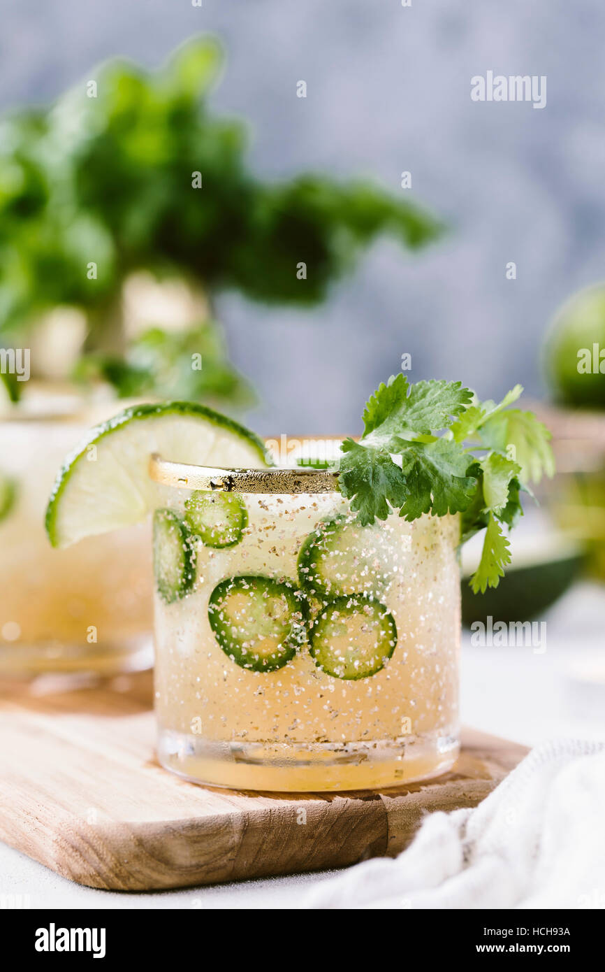 A couple glasses of spicy jalapeno margaritas are photographed from the front view. Stock Photo