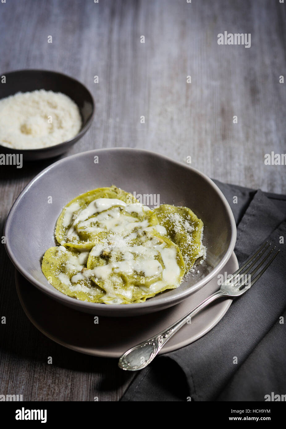 Ravioli with Parmesan sauce on grey background Stock Photo