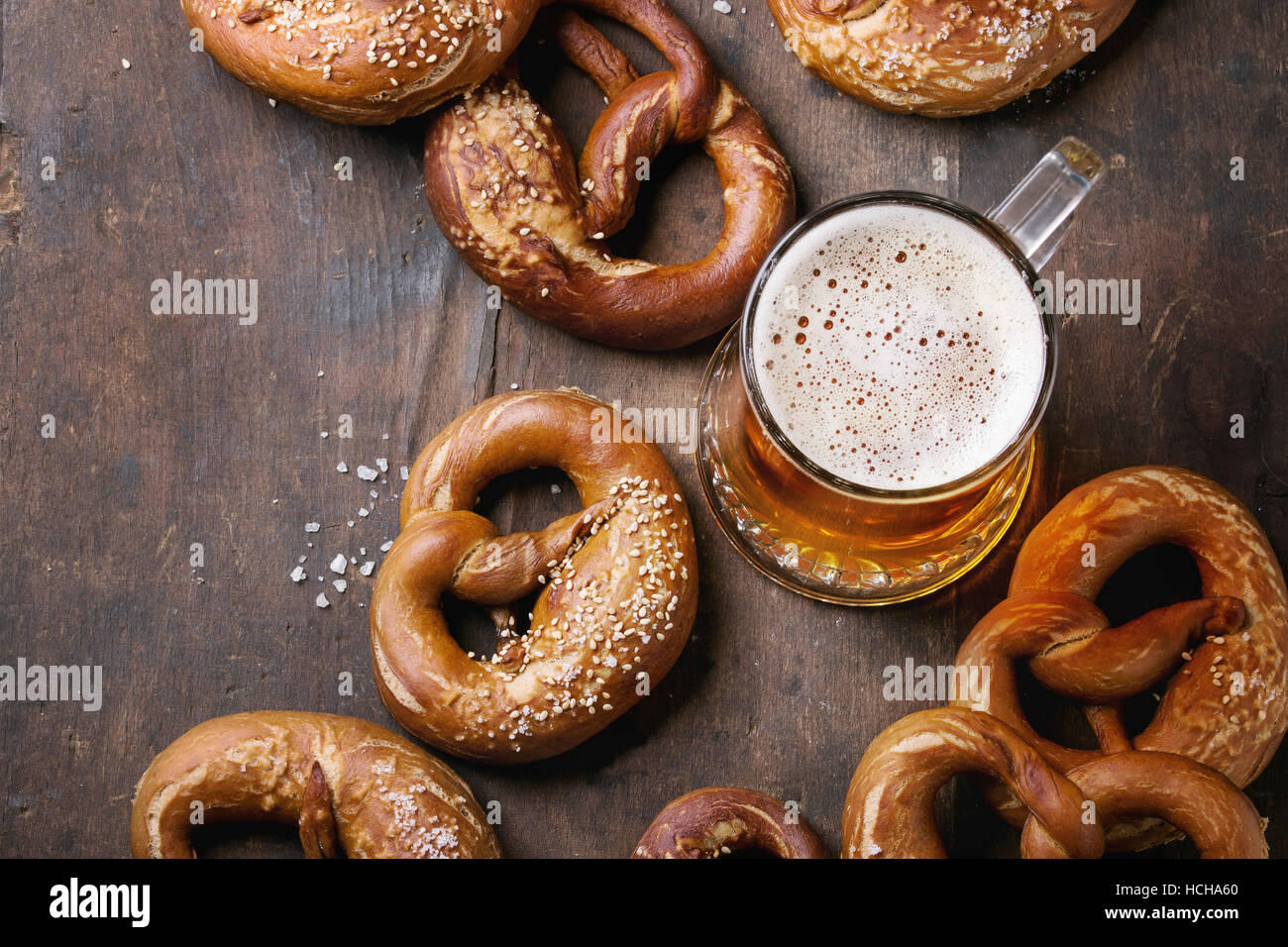 Glass of lager beer with traditional salted pretzels over old dark wooden background. Top view with space for text. Oktoberfest theme Stock Photo