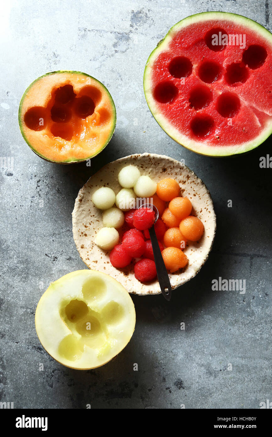 Cantaloupe,honeydew and watermelon balls on a plate with fresh melon in background Stock Photo