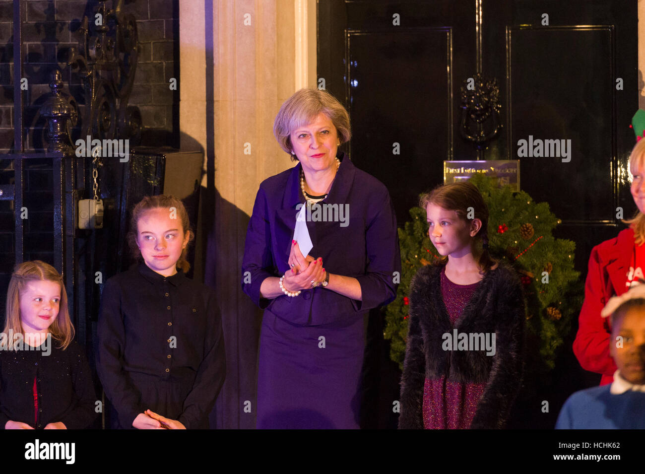 London, UK. 8th December, 2016. Theresa May the British Prime Minister with children nominated by UK charities and a local school choir switching on the Downing Street Christmas tree lights. With 3 girls from her constituency who won a competition to design this years Christmas card for the Prime Minister. Credit:  Alex MacNaughton/Alamy Live News Stock Photo