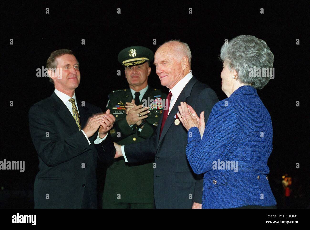 United States Secretary of Defense William S. Cohen (left) applauds U.S. Senator John H. Glenn, Jr (Democrat of Ohio) (second from right) after presenting him the Department of Defense Medal for Distinguished Public Service at an armed forces review and award ceremony at Fort Myer, Virginia, on December 4, 1998. Joining in the celebration are Chairman of the Joint Chiefs of Staff General Henry H. Shelton, (second from left) and Mrs. Annie Glenn (right). Cohen presented the medal to Glenn for his distinguished service to the nation. Mandatory Credit: Helene C. Stikkel/DoD via CNP /MediaPun Stock Photo