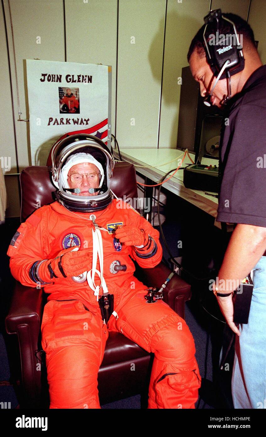 STS-95 Payload Specialist John H. Glenn Jr., senator from Ohio, tests the fitting of his flight suit in the Operations and Checkout Building while suit tech George Brittingham watches. The final fitting takes place prior to the crew walkout and transport to Launch Pad 39B. Targeted for launch at 2 p.m. EST on October 29, 1998, the mission is expected to last 8 days, 21 hours and 49 minutes, and return to KSC at 11:49 a.m. EST on Nov. 7. The STS-95 mission includes research payloads such as the Spartan solar-observing deployable spacecraft, the Hubble Space Telescope Orbital Systems Test Platfo Stock Photo