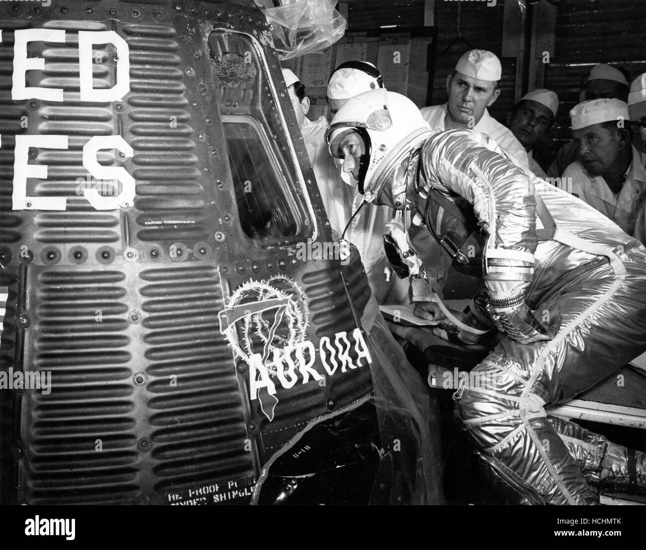 Astronaut Scott Carpenter looks inside the Aurora 7 spacecraft prior to insertion. McDonnell and NASA capsule technicians along with Astronaut Wally Schirra and John Glenn watch Carpenter prepare for his programmed three-orbit mission at Cape Canaveral, Florida, May 24, 1962. Credit: NASA via CNP /MediaPunch Stock Photo