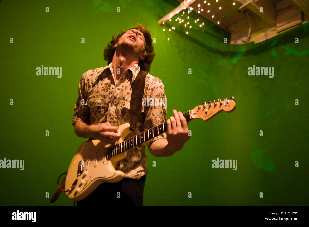 Guitarist and singer Tom Beecham, frontman of The Raggedy Anns, performs with rock band Song Sparrow Research at an underground music venue in Seattle, Washington. Stock Photo