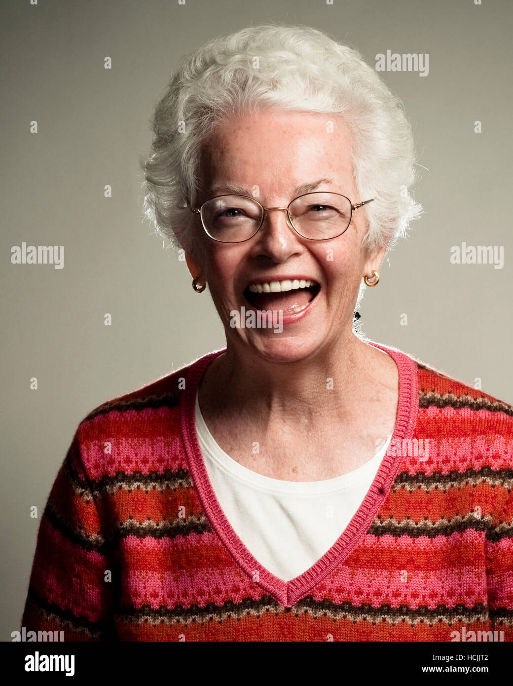 A studio portrait of a joyous silver-haired lady. Stock Photo