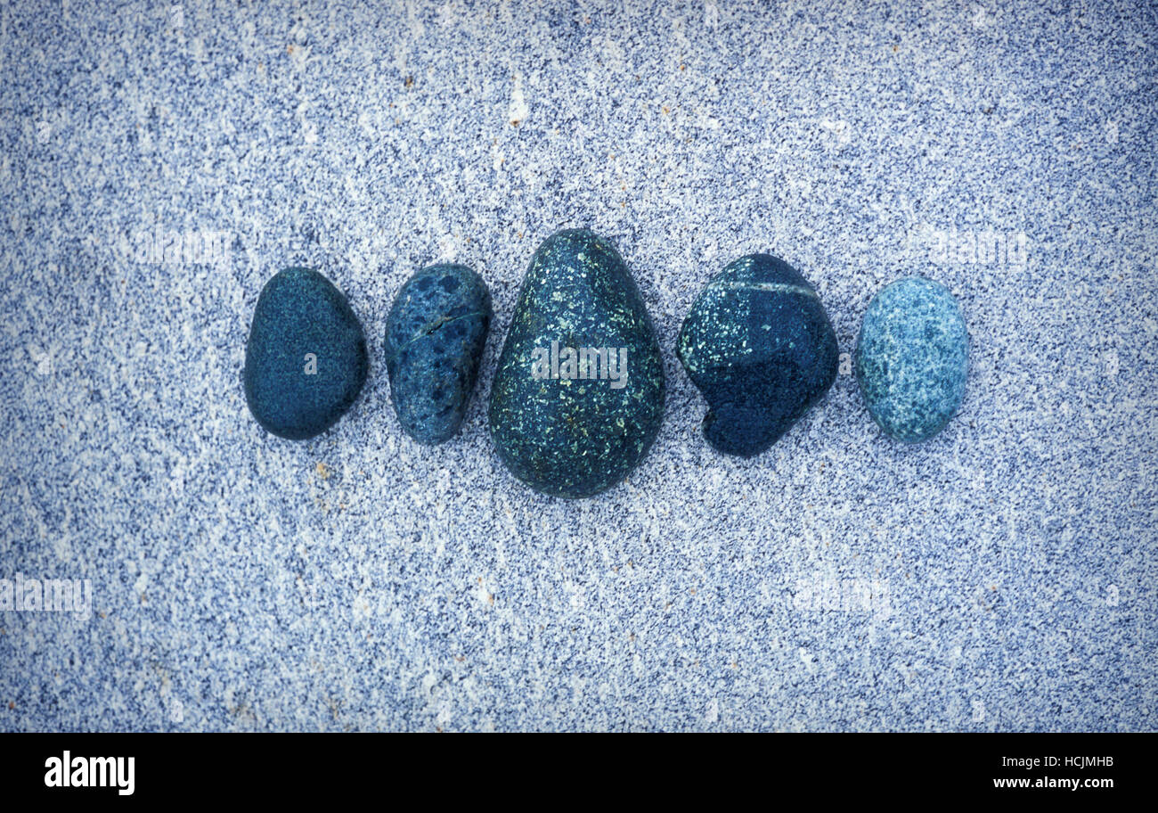 Rocks shaped and smoothed by the ocean are in an arrangement on a large ...