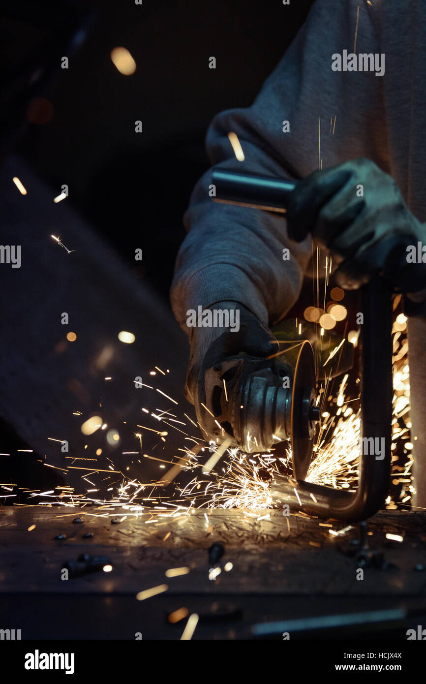 Worker cutting metal pipe using angular grinding machine. Horizontal photo. Stock Photo