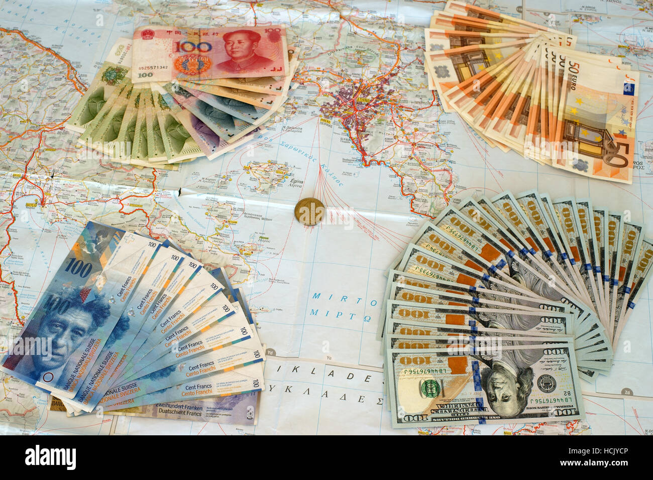 Euro, yuan, us dollars and swiss frank banknotes on map of Greece. Symbolize greek default and foreign interests. Stock Photo