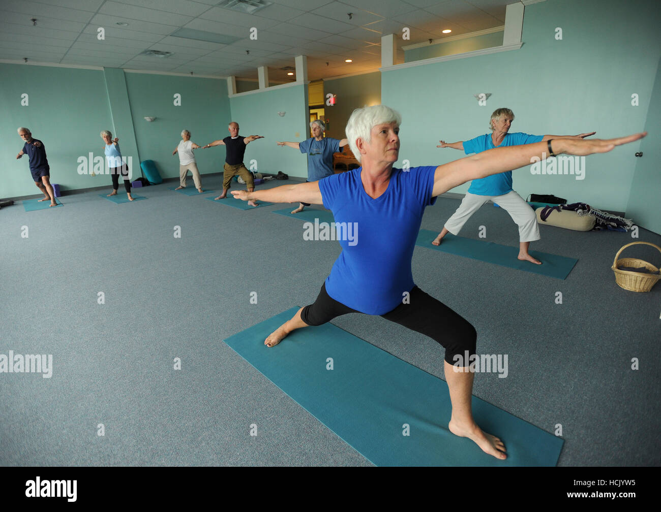 Yoga instructor Jennifer Cooper leads a class of seniors through a variety of stretches and yoga positions at the Yoga Center in Portland, ME August 24, 2010. Stock Photo