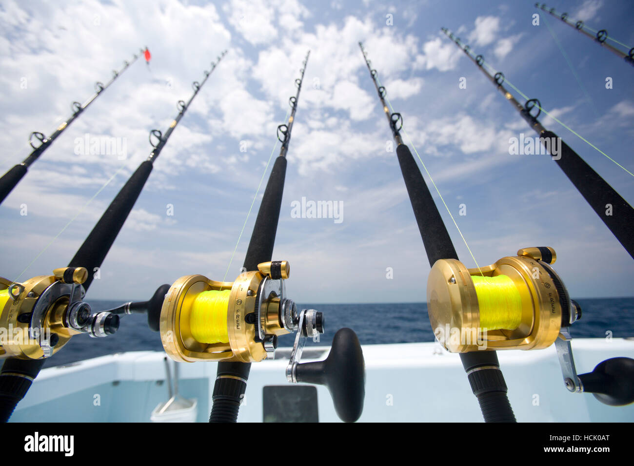 A wide-angle shot of deep sea fishing rods ready for action with blue sky  and clouds in the background Stock Photo - Alamy