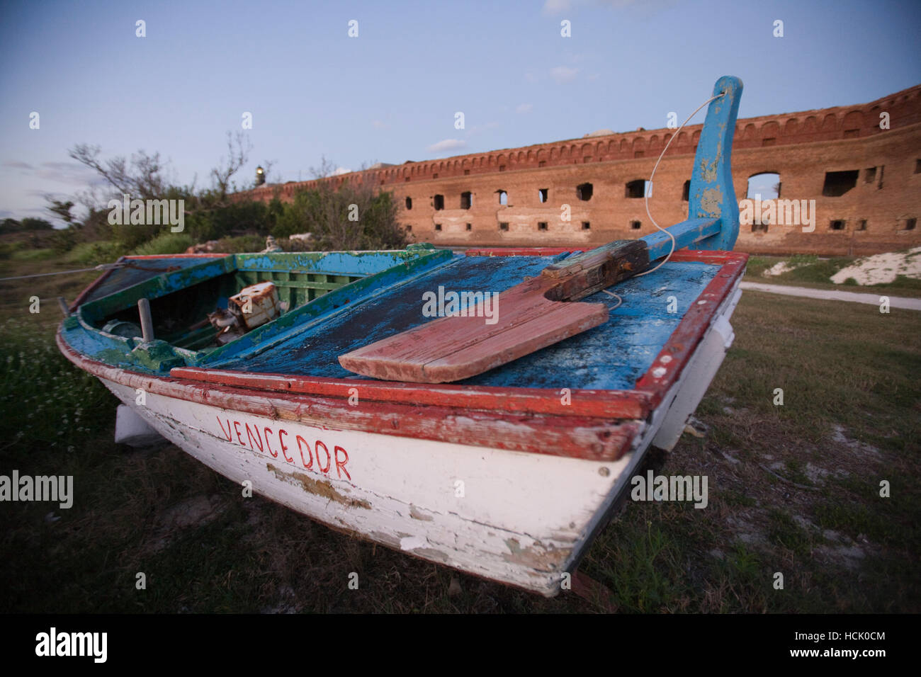 A shipwrecked Cuban refugee boat sits in front of the Fort Jefferson Fortress. Stock Photo