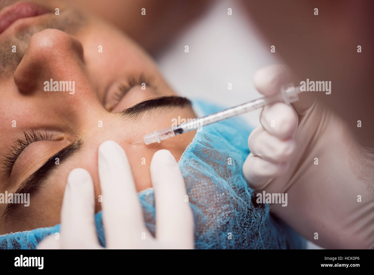 Man receiving botox injection on his forehead Stock Photo - Alamy