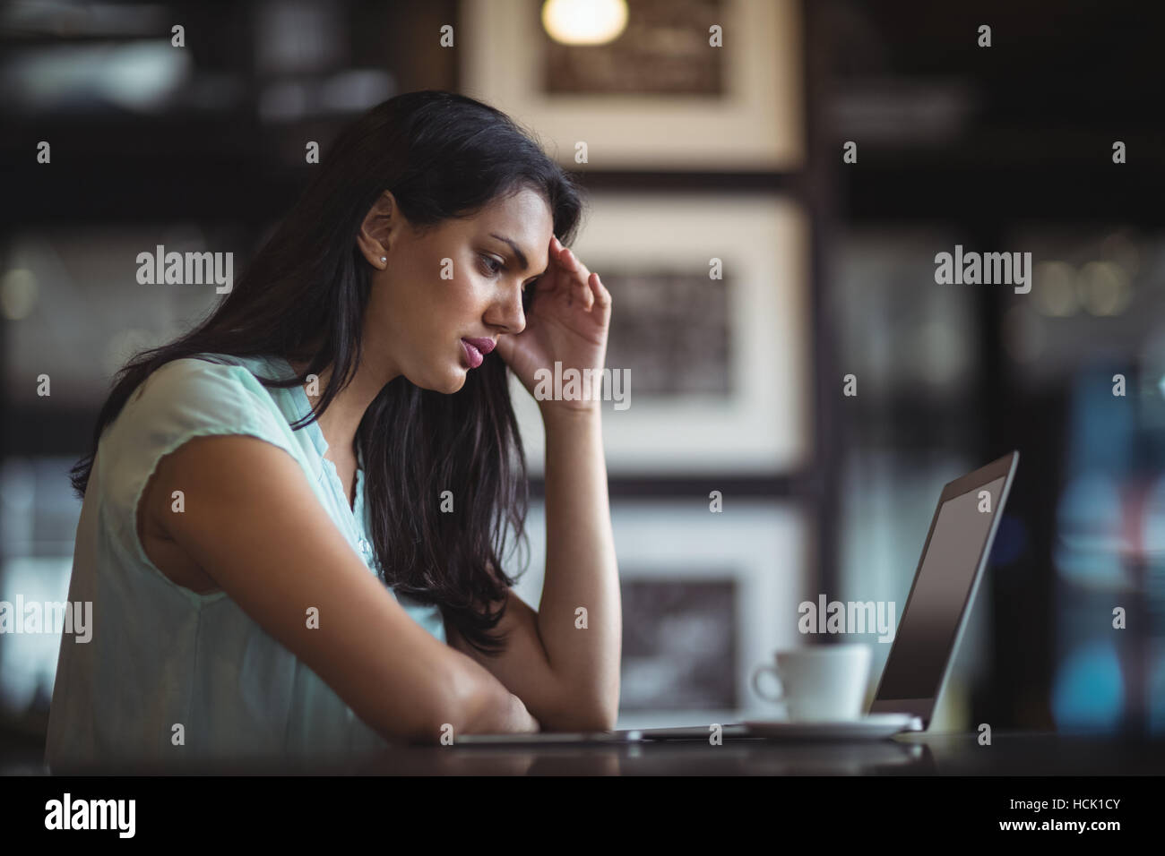 Upset businesswoman sitting at her desk Stock Photo