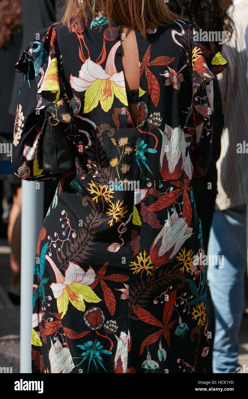 Woman with black dress with floral pattern before Stella Jean fashion show, Milan Fashion Week street style on September 25. Stock Photo