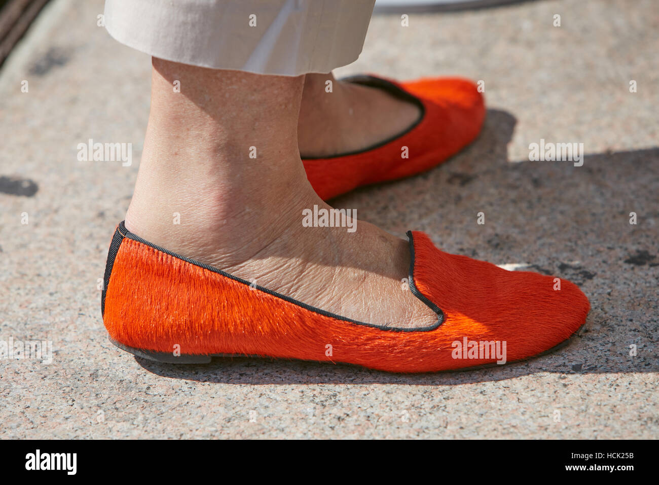 Woman with orange fur shoes before Stella Jean fashion show, Milan Fashion Week street style on September 25, 2016 in Milan. Stock Photo