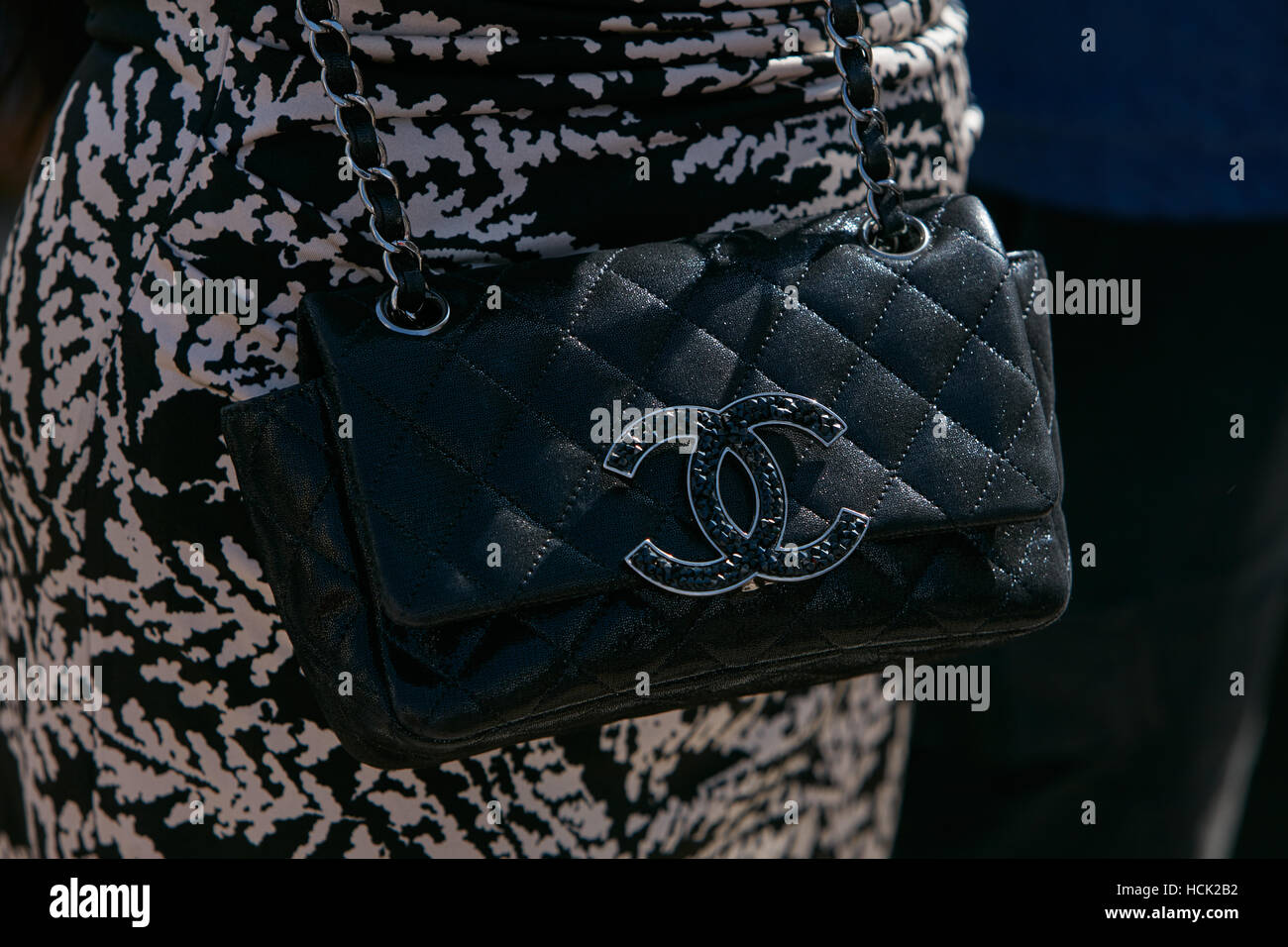 Woman with black leather Chanel bag before Stella Jean fashion show, Milan Fashion Week street style on September 25, in Milan. Stock Photo