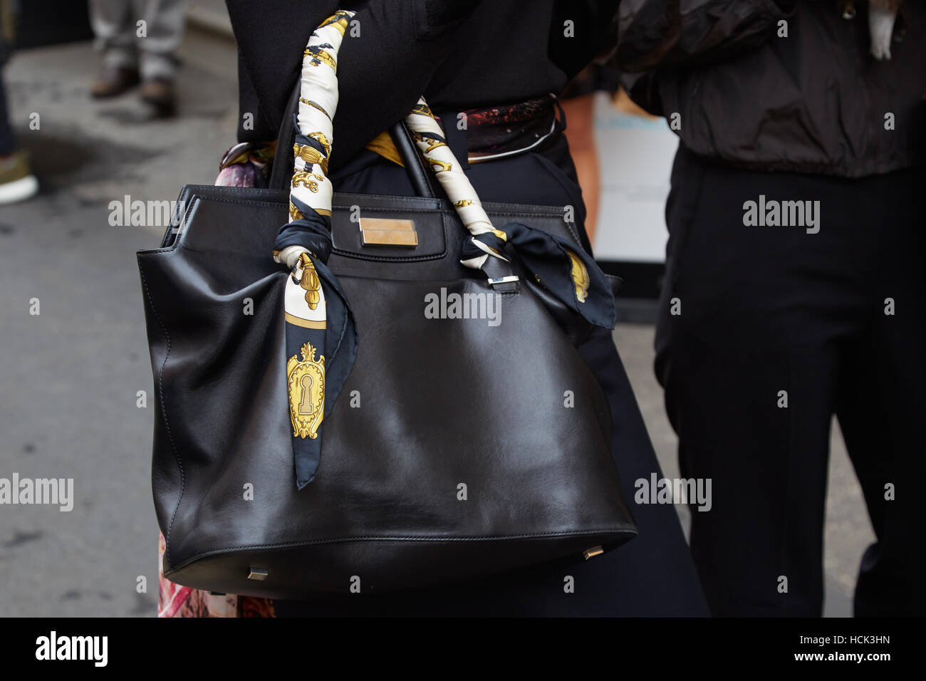Woman with black leather bag and silk headscarf before Wunderkind fashion show, Milan Fashion Week street style on September 21. Stock Photo