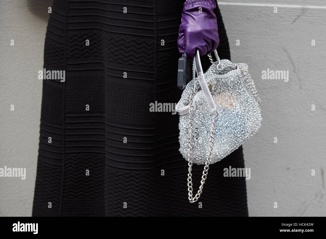 Woman with silver net bag and purple glove before Anteprima fashion show, Milan Fashion Week street style on September 22. Stock Photo
