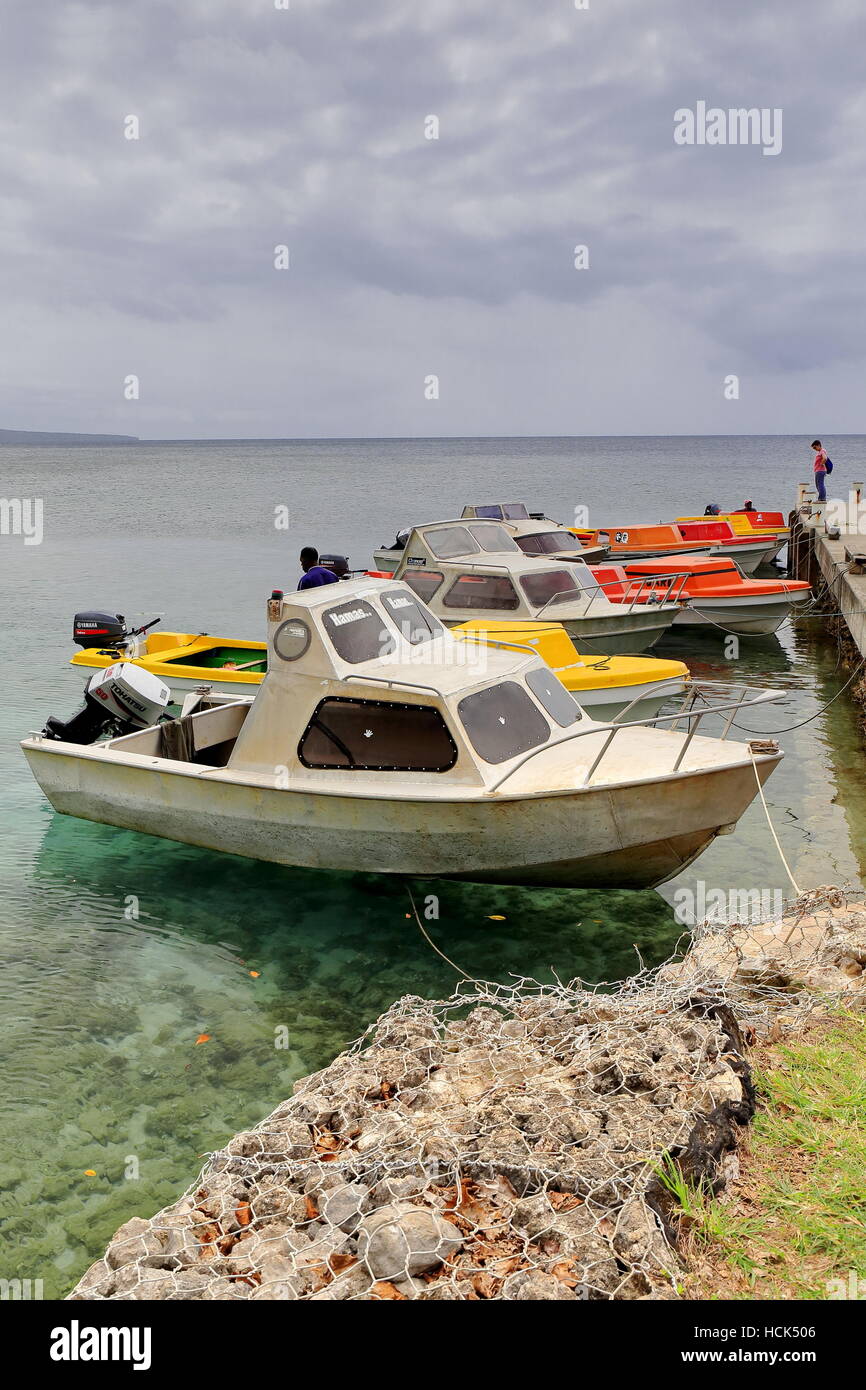 Emua, Vanuatu-October 3, 2014: Local motorboats rest moored to the jetty on the North shore of Efate island while waiting for the weather to get bette Stock Photo