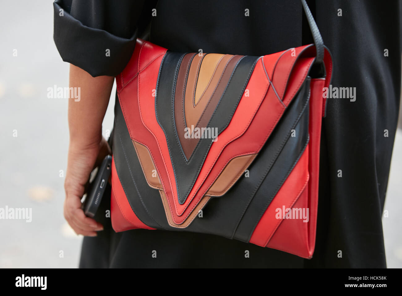Woman with red, black geometrical leather bag before Gucci fashion show, Milan Fashion Week street style on September 21, 2016. Stock Photo