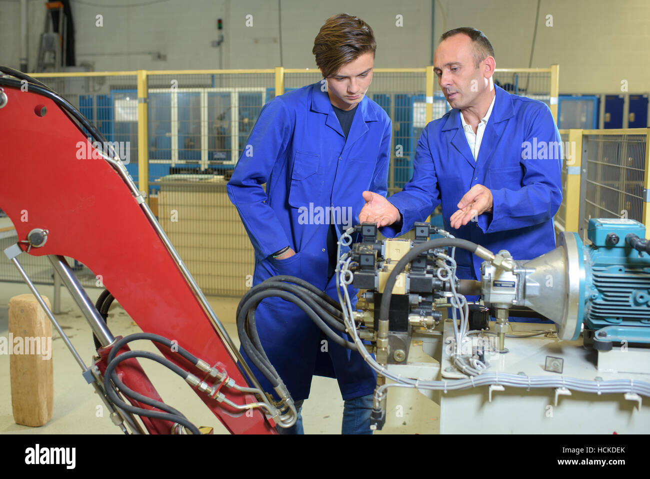Engineers looking at hydraulic arm mechanicsm Stock Photo Alamy