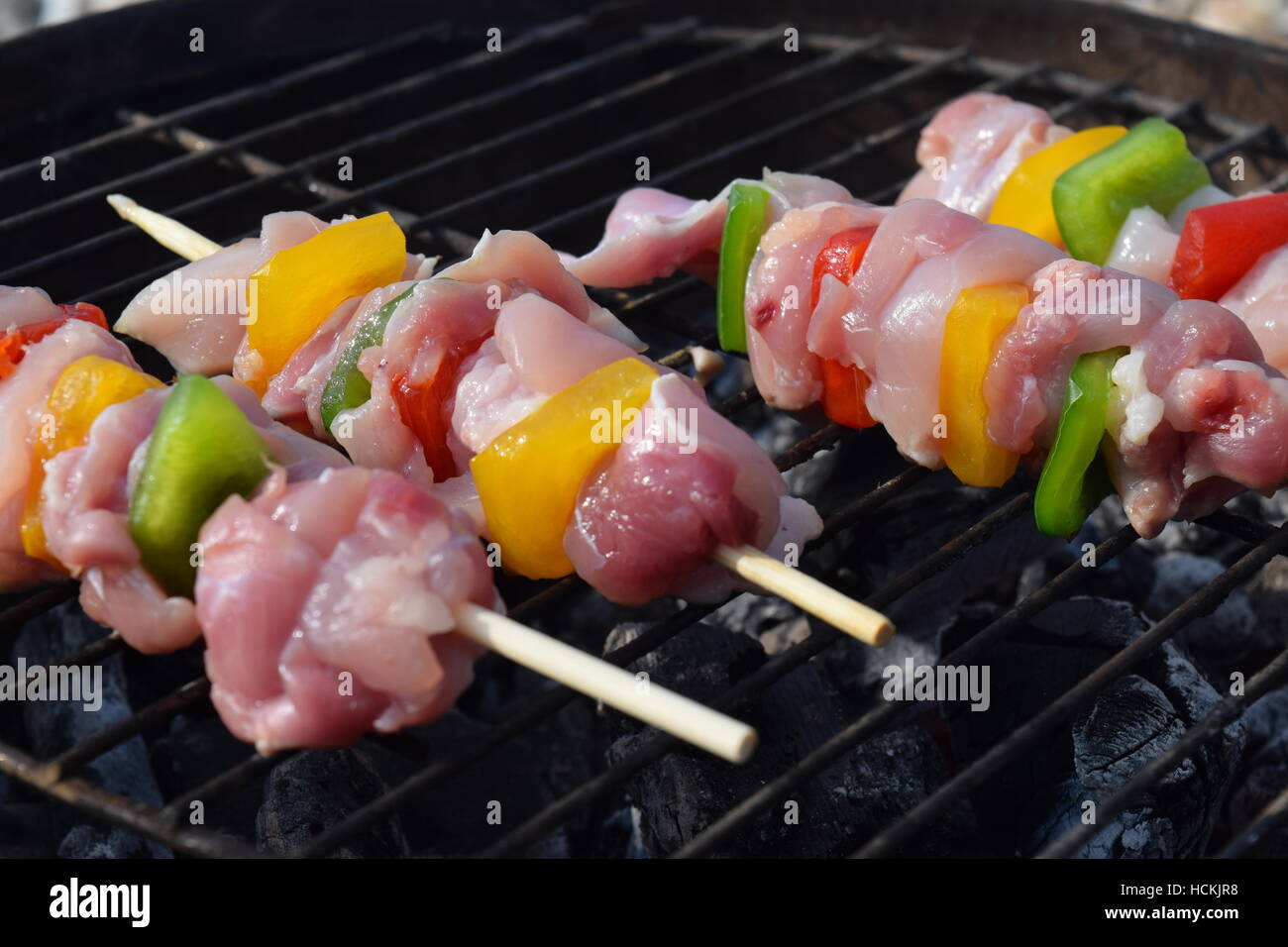 Prepared chicken skewers cooking on a barbecue grill at the Isle of