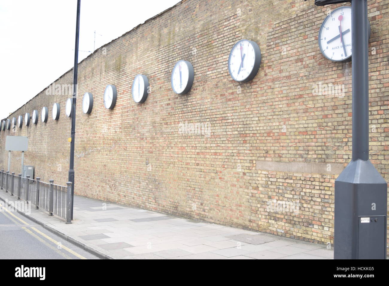 World clocks on a brick wall at a train station in London Stock Photo
