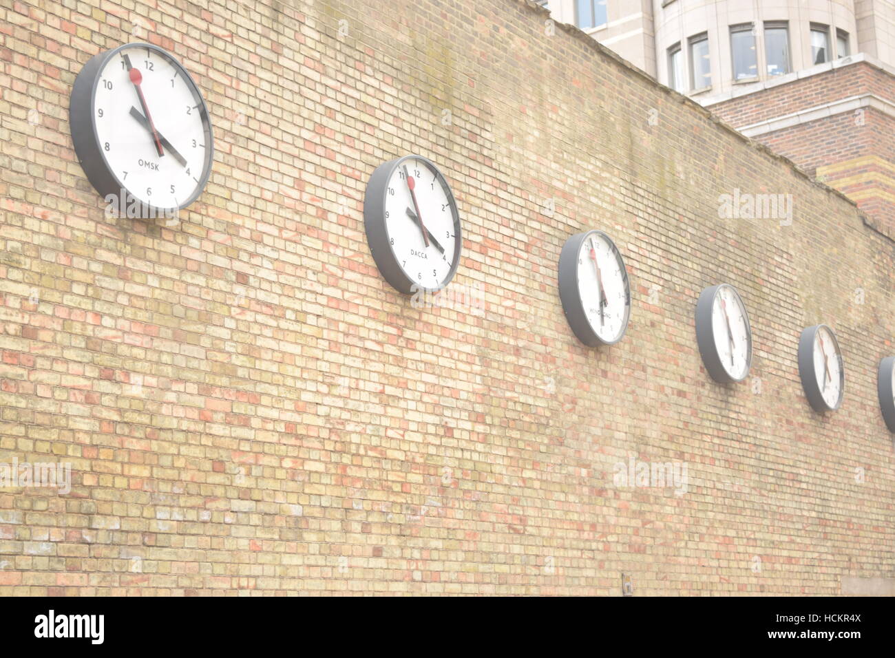 Line of international clocks on a brick wall Stock Photo Alamy