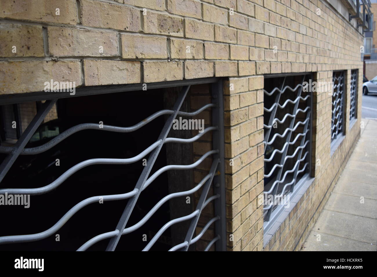 Close perspective of strong metallic bars cover windows in a brick wall