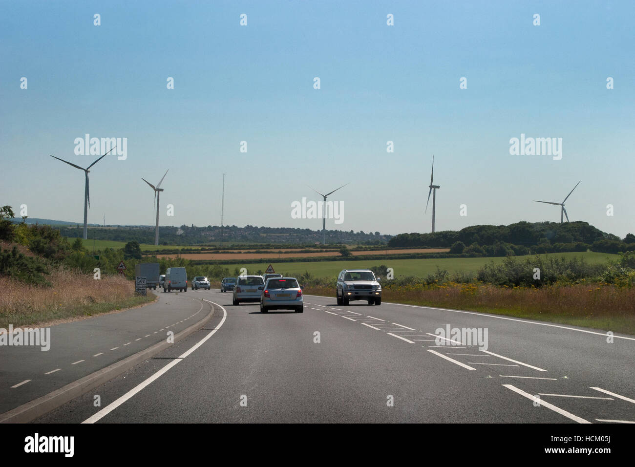 low level windfarm towers above road Stock Photo