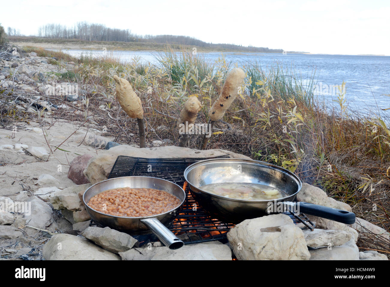 Bannock on a stick, a native North American food similar to bread, cooked on a campfire in Northern Ontario, Canada. Stock Photo