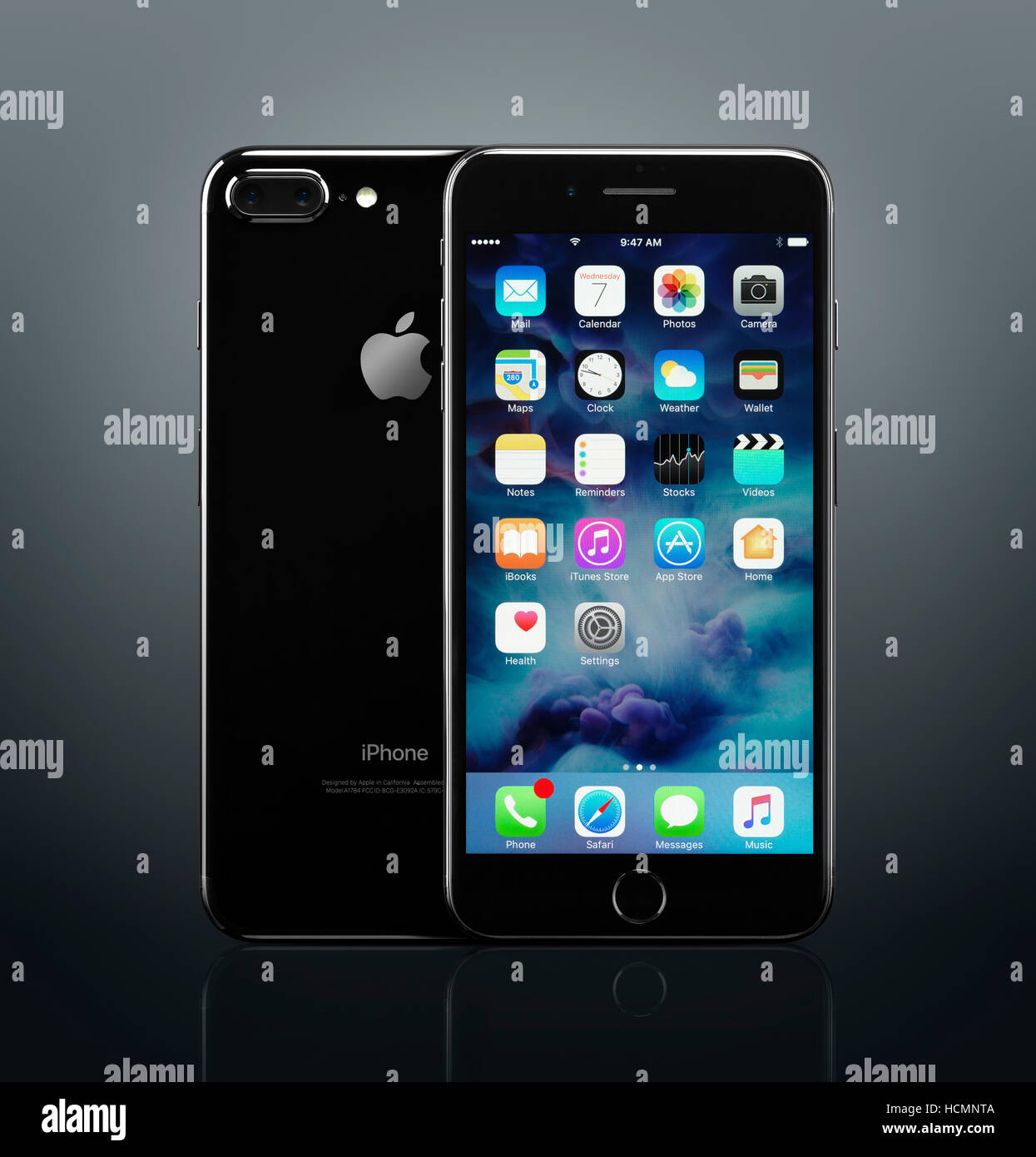 Apple iPhone 7 Plus black front and back with desktop icons on its display isolated on dark gray background Stock Photo