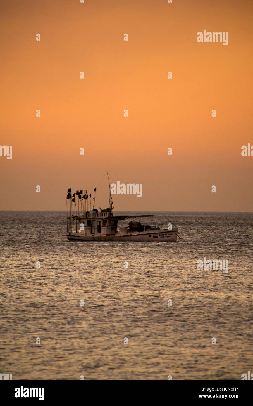 Fishing boat in the sea on sunset Stock Photo