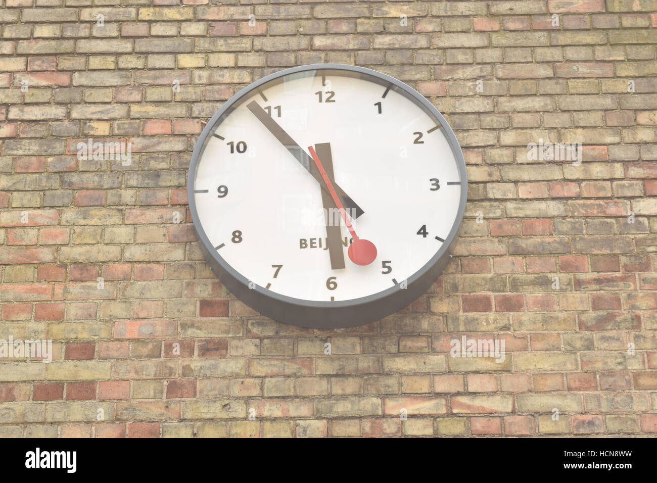 Clock showing Beijing time on a brick wall Stock Photo Alamy