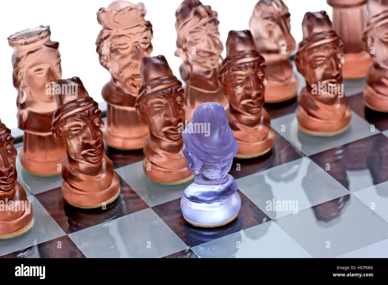 White pawn againts black pieces on glass made chess board Stock Photo