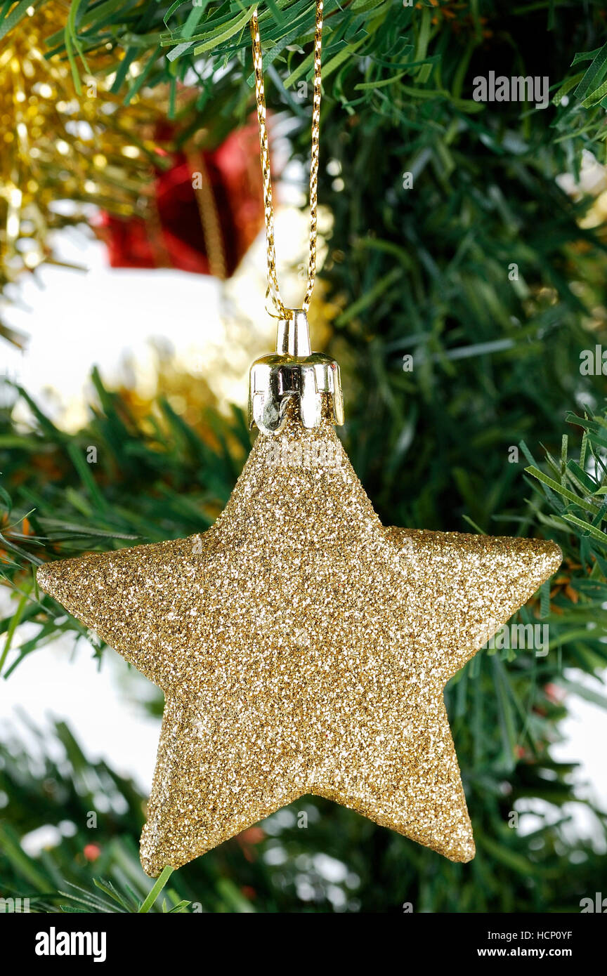 Christmas gold star hanging on tree over white background Stock Photo ...