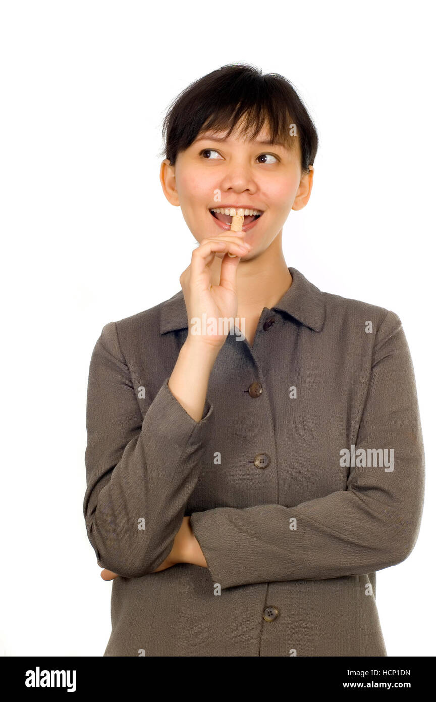 Young Beatiful Asian Woman eating cookie on white background Stock Photo
