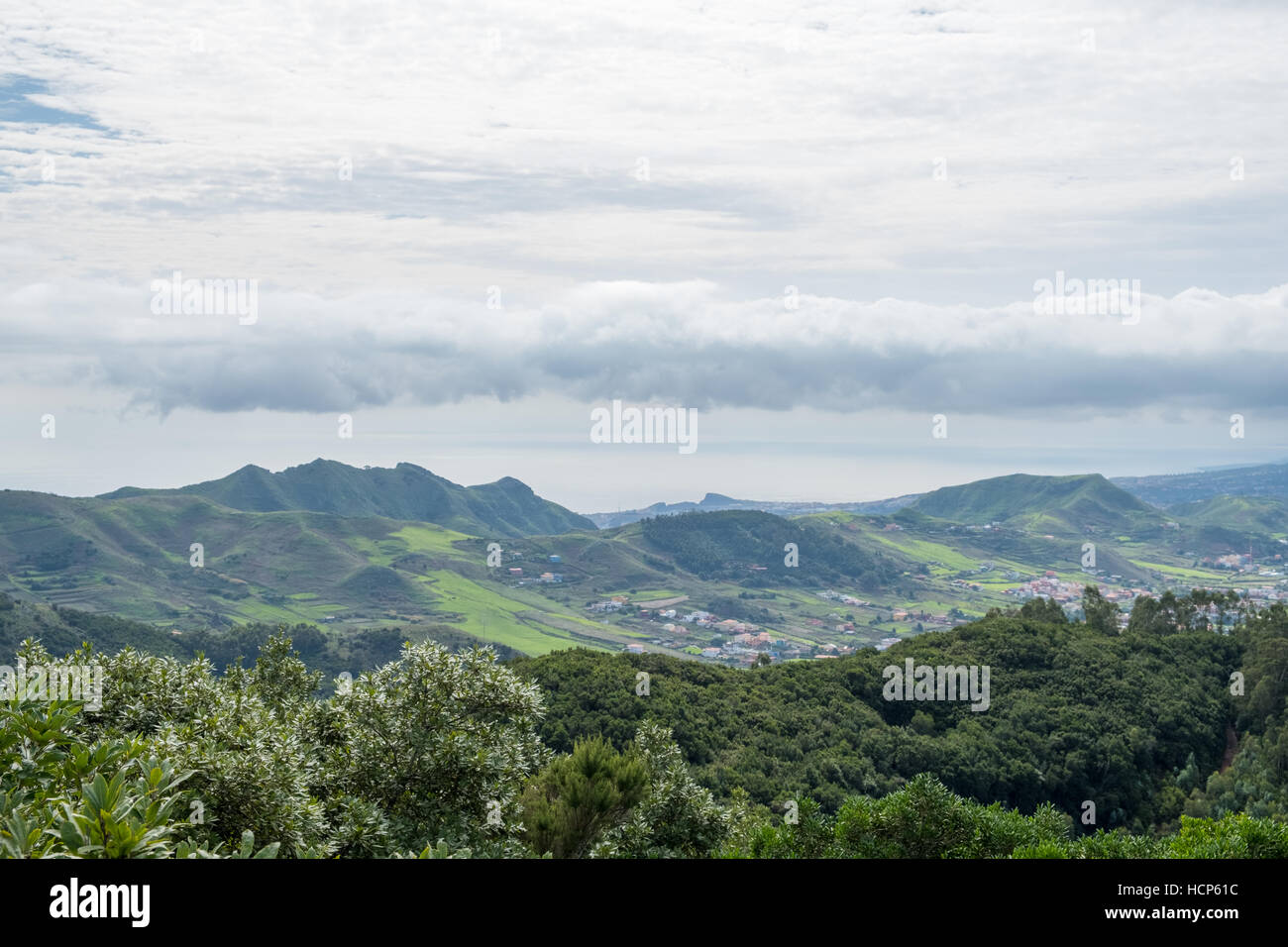 Green valley with village, hills and ocean background, Tenerife Stock Photo