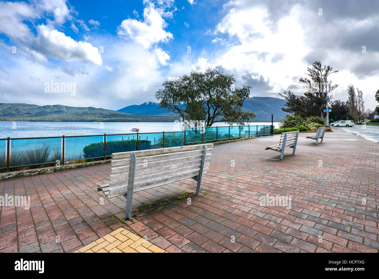 A row of wooden brench in front of Te anau lake, New Zealand Stock Photo