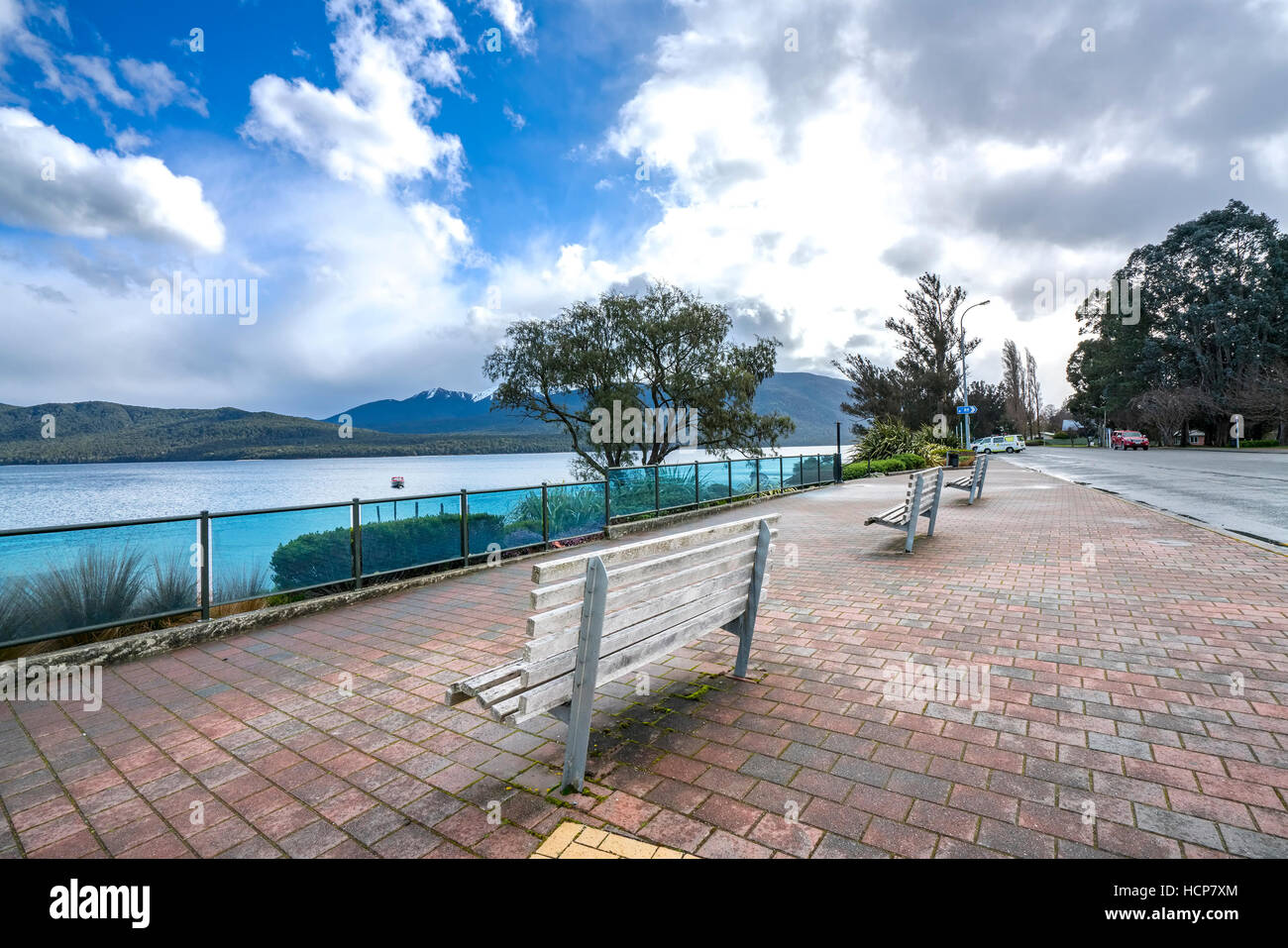 A row of wooden brench in front of Te anau lake, New Zealand Stock Photo