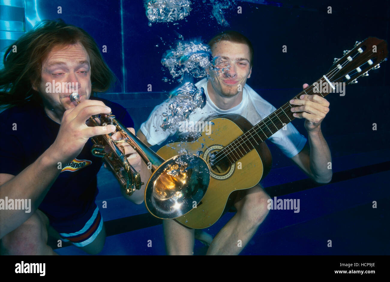 Musicians playing trumpet and guitar under water Stock Photo